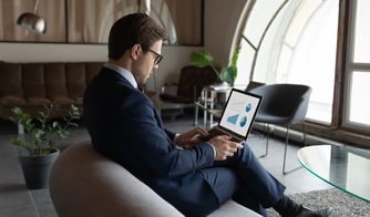 Análisis de datos empresariales en el portátil Ejecutivo revisando gráficos y métricas en una computadora portátil