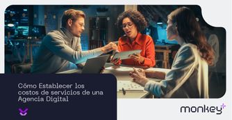 Cómo establecer los costos de servicios de una agencia digital Equipo de trabajo en reunión analizando estrategias con laptop y tablet en oficina moderna